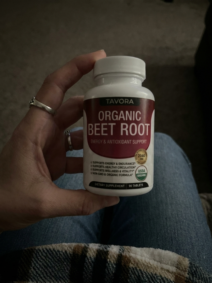 Teresa W. holding a bottle of Tavora Organic Beet Root